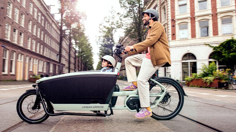 Vader en zoon op de bakfiets door Amsterdam