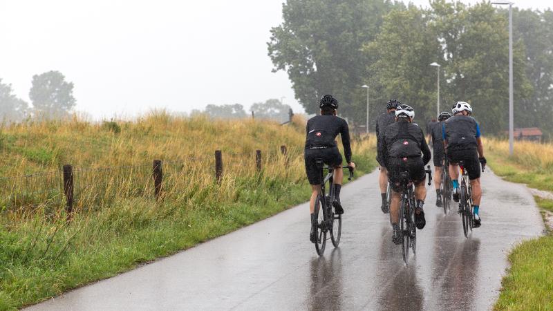 Groep wielrenners in de regen.