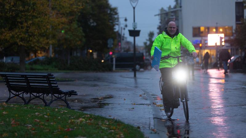 Stadsfietser in Arnhem in de regen.