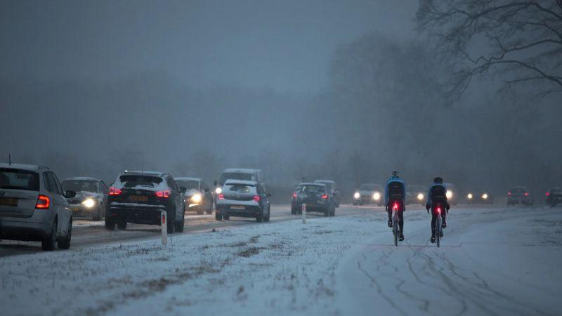 2 wielrenners over besneeuwd fietspad. 
